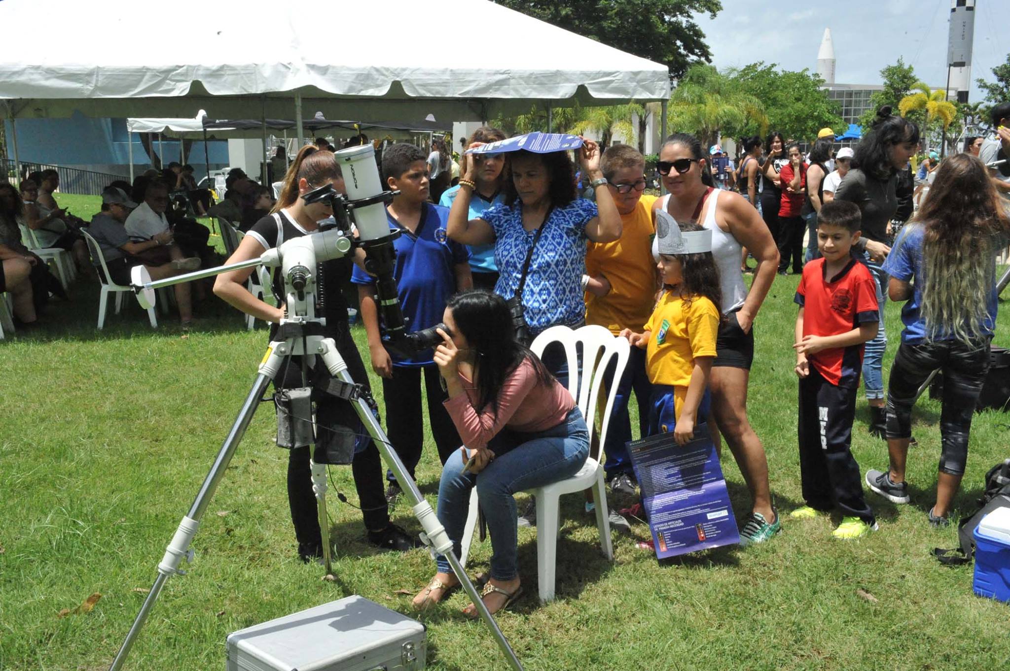 Visitantes apreciando el eclipse solar desde un telescopio