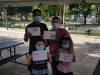 Familia participante del taller mostrando sus obras